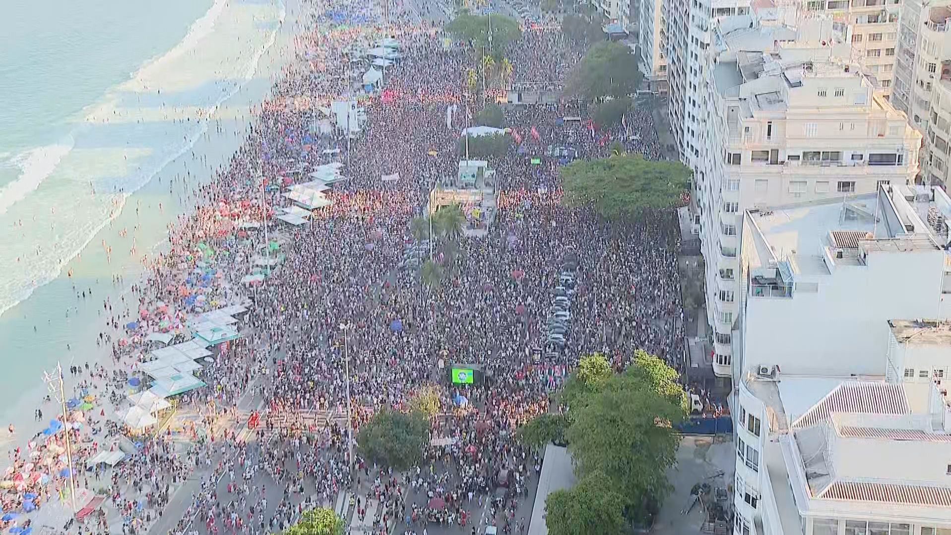 Pessoas segurando cartazes e bandeiras