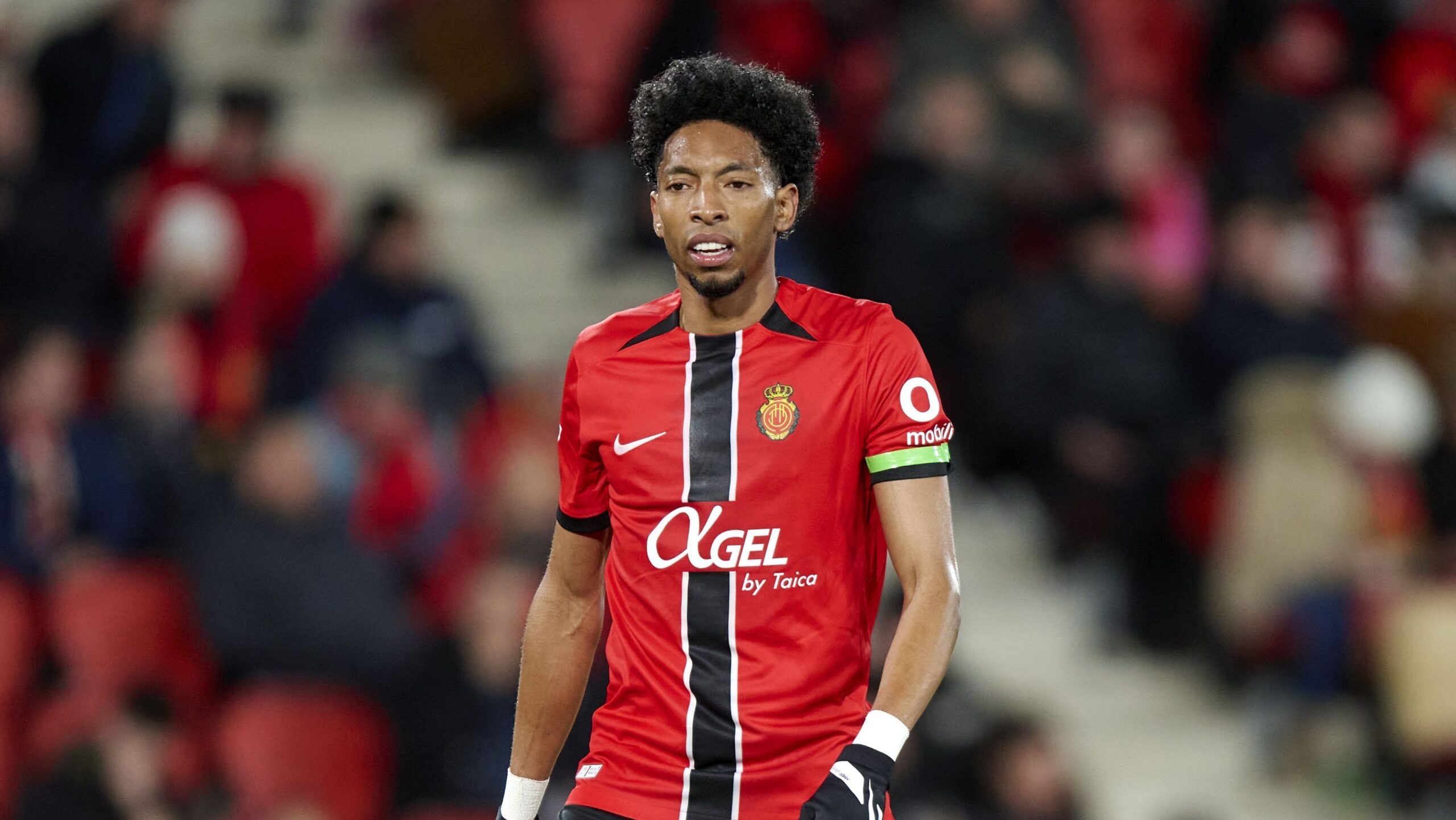 Jogador de futebol correndo com a bola